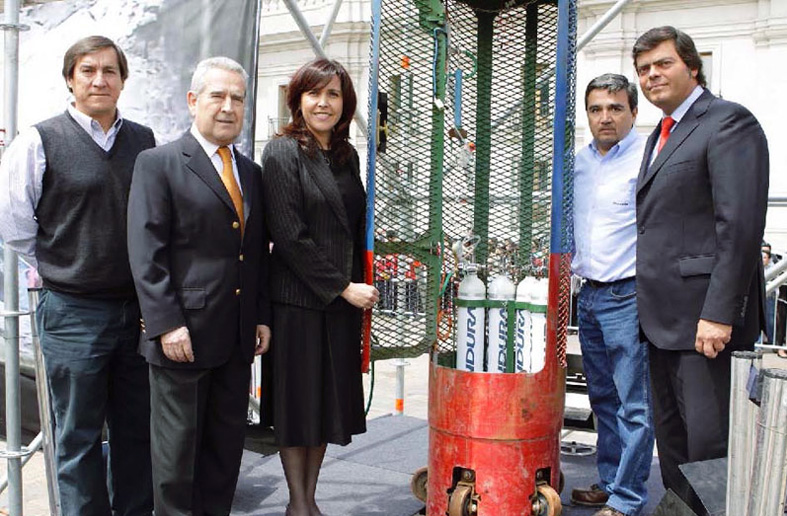 Indura personnel pose with the Fnix capsule and Luxfer oxygen cylinders used in the successful rescue of 33 miners. They are (from left to right) Alberto Perez, Engineering Projects Manager Ren Le Feuvre, Corporate Commercial Manager Alicia Morales, Medical Business Development Manager Alejandro Symmes, Gases and Specialty Mixtures Manager and Cristin Barra, Consultant from the Chilean Government Ministry of the Interior.