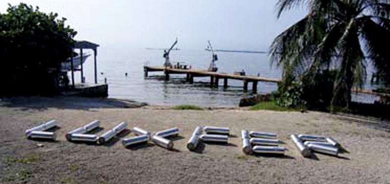 Student divers spelled out LUXFER on the beach with tanks